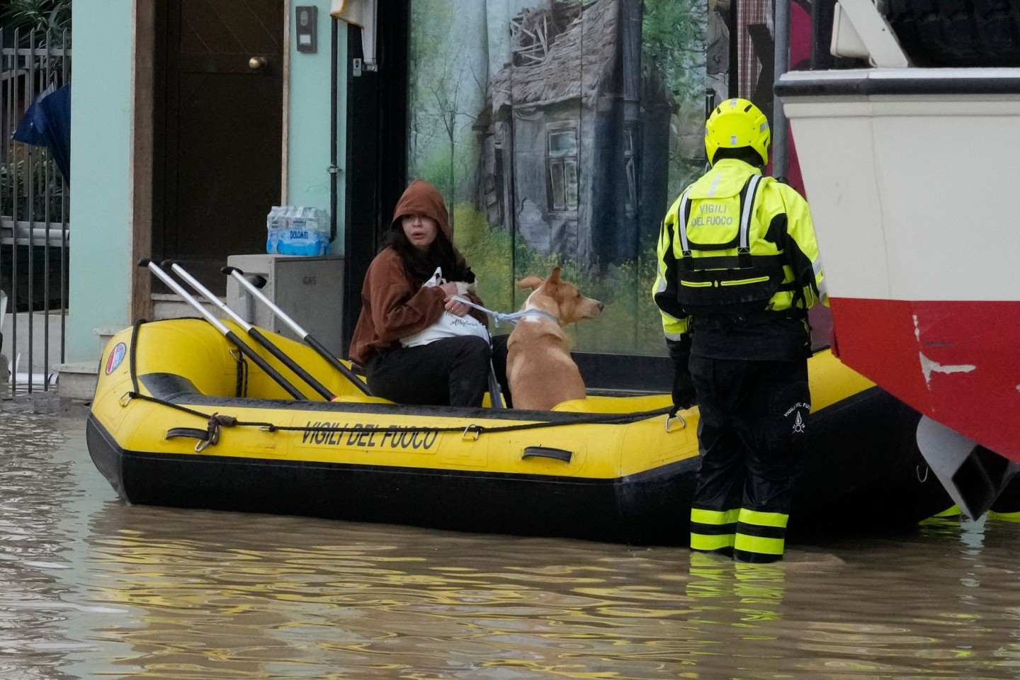 Feuerwehrleute retten eine Anwohnerin und ihren Hund im Ort Campi di Bisenzio.