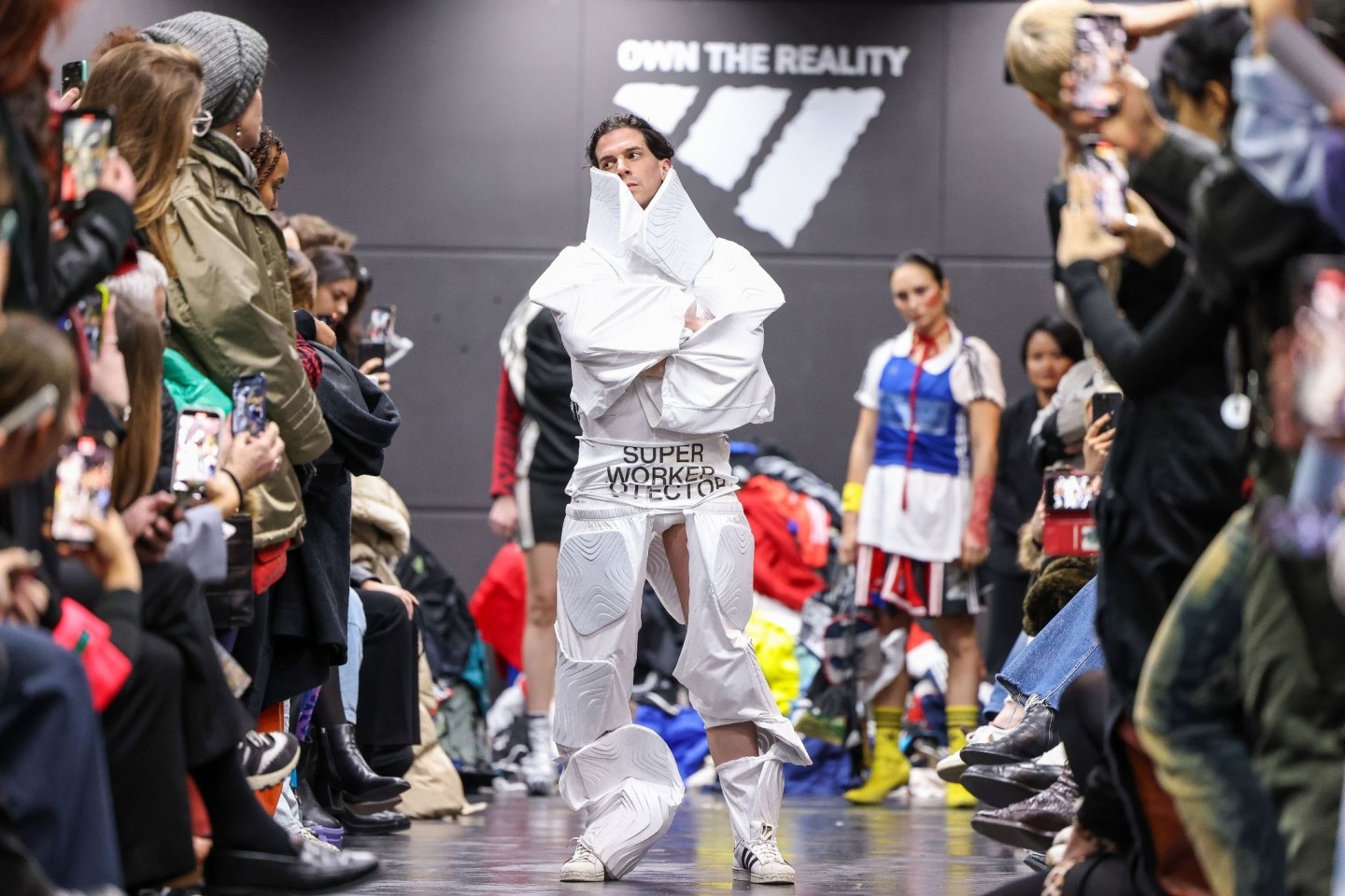 Ein Aktivist bei einer als Adidas-Show getarnten Performance auf dem Catwalk.