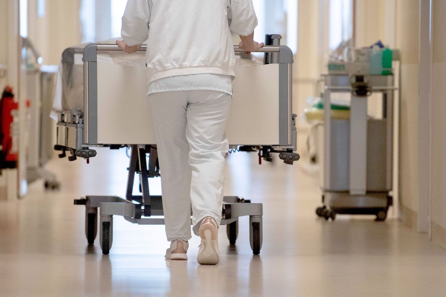 Eine Krankenpflegerin schiebt ein Krankenbett durch einen Flur: Mehr Frauen als Männer fürchten sich einer Umfrage zufolge vor einem stationären Aufenthalt im Krankenhaus.
