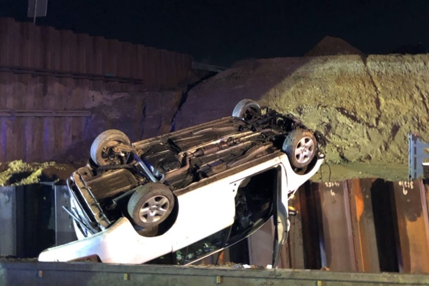 Das Auto liegt auf dem Dach, nachdem es von einer demontierten Autobahnbrücke gestürzt ist. Der Fahrer wurde leicht verletzt.
