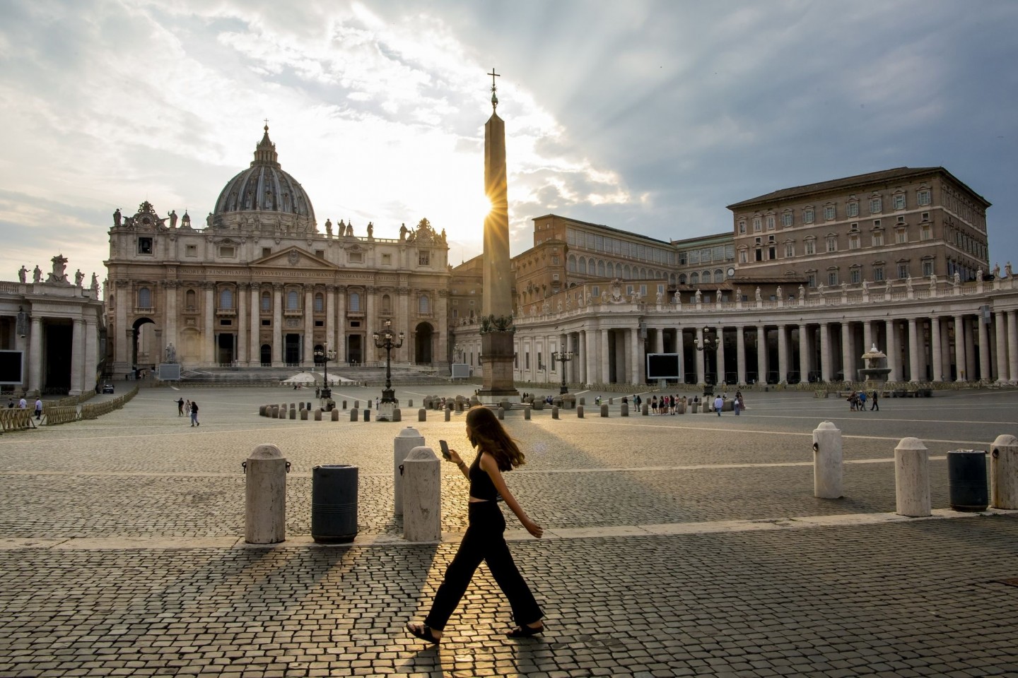 Eine Frau spaziert auf dem Petersplatz. Betrüger sollen sich als Vermittler des Vatikan ausgegeben und mit angeblichen Finanzierungsgeschäften für einen Millionenschaden gesorgt haben.