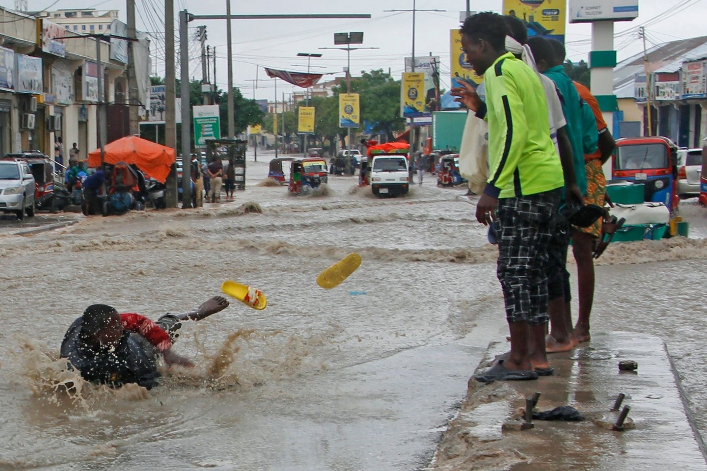 Ein Mann rutscht nach starken Regenfällen im Hochwasser aus.