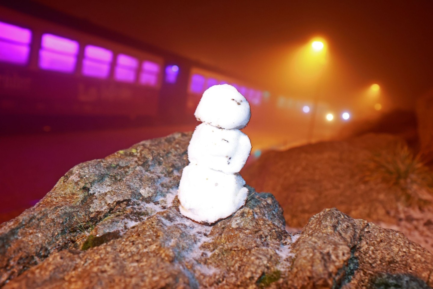 Ein kleiner Schneemann steht auf einem Stein auf dem Brocken.