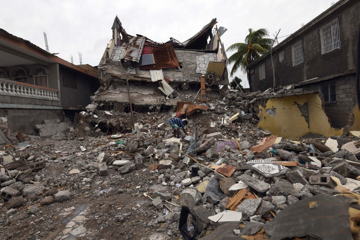 Ein junger Mann sucht in den Trümmern eines eingestürzten Gebäudes.