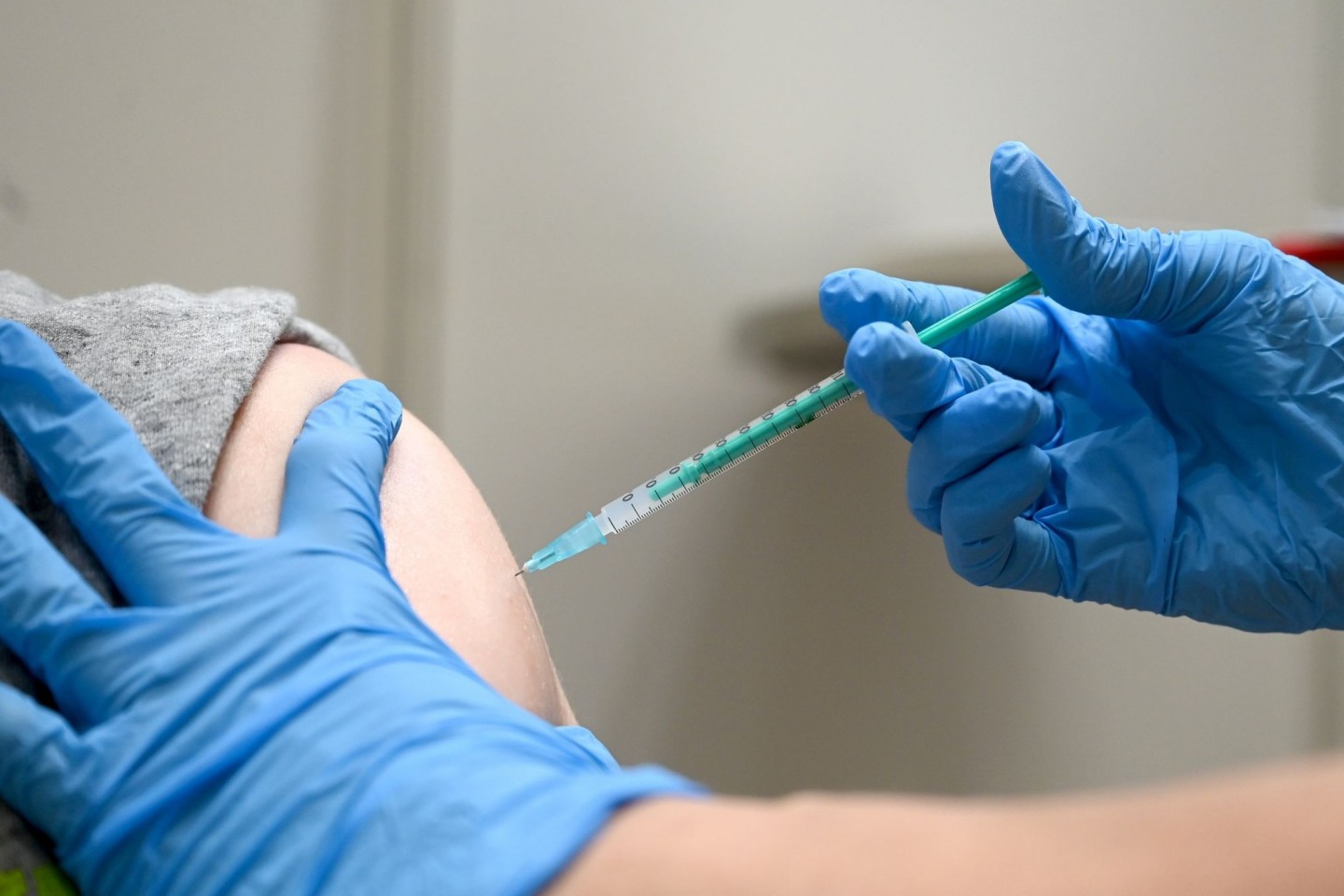 Eine Ärztin impft einen Mann mit einem Corona Impfstoff.
