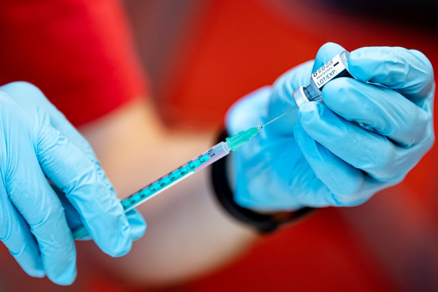 Eine Notfallsanitäter der DLRG zieht an der Universität Potsdam einen Corona-Impfstoff in eine Spritze.