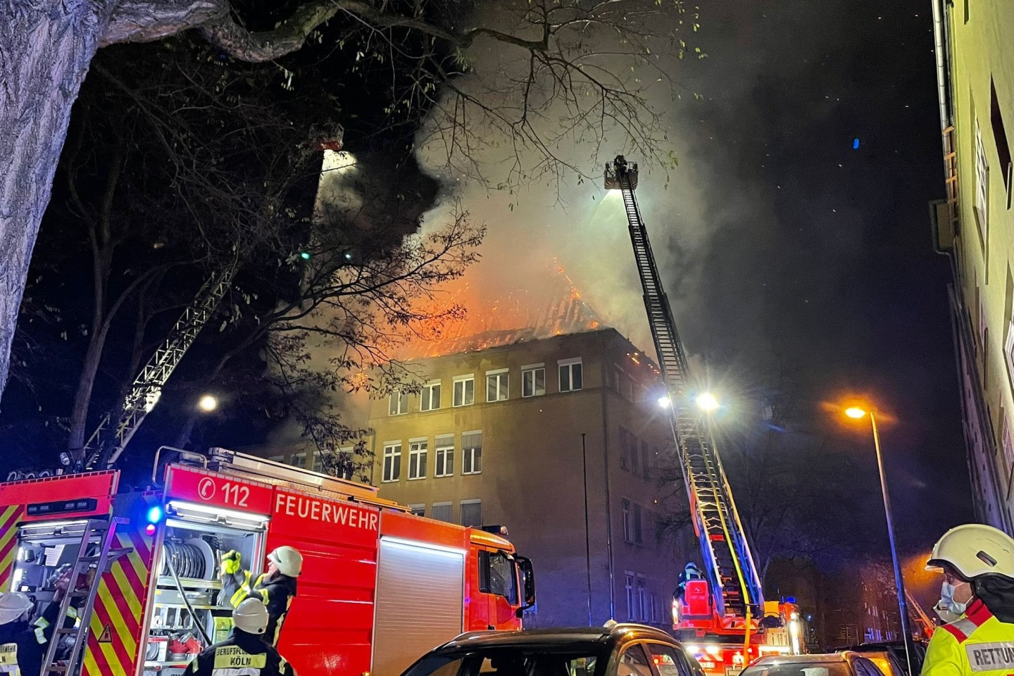 Einsatzkräfte der Feuerwehr löschen das brennende Schulgebäude.