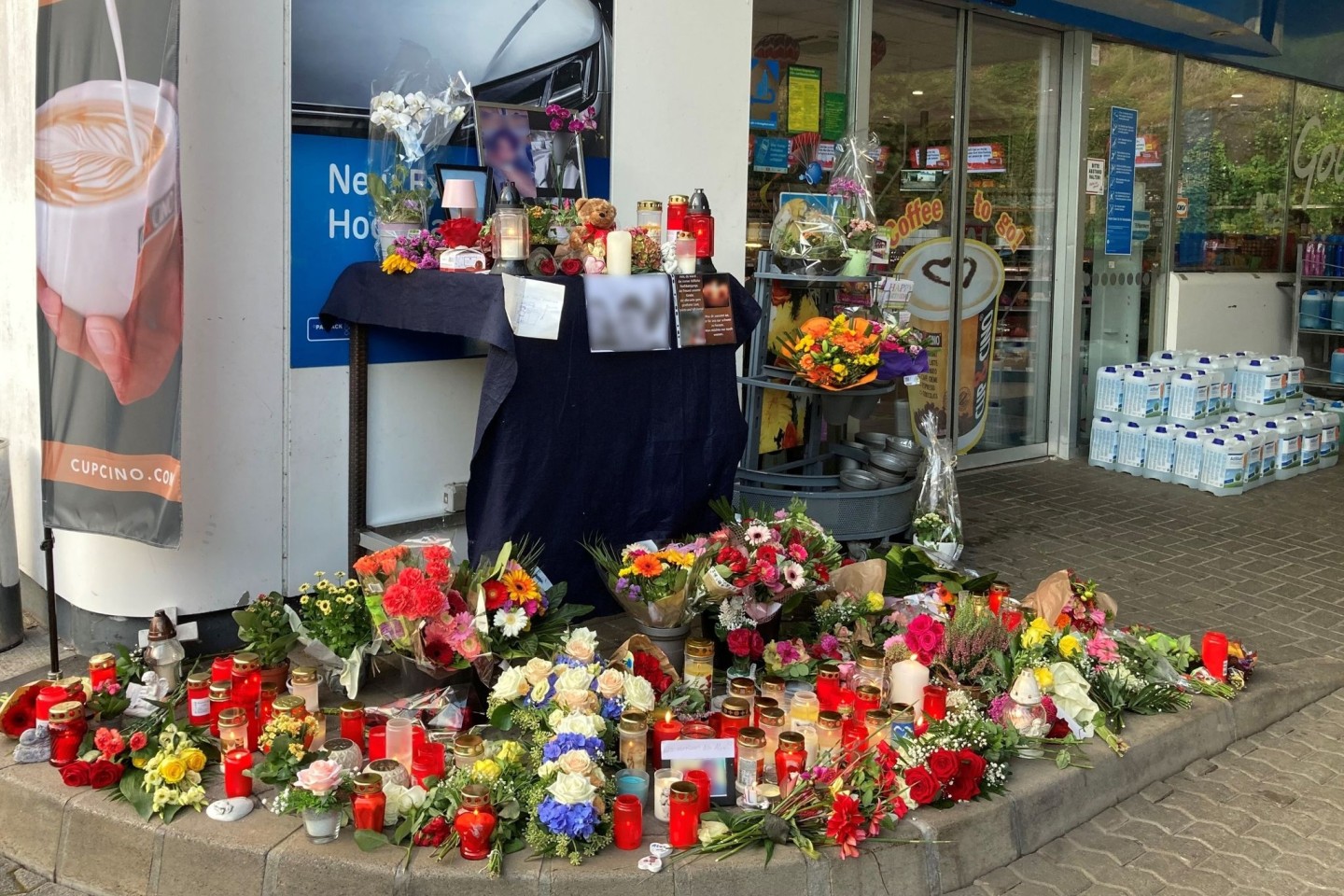 Blumen und Kerzen erinnern an einer Tankstelle in Idar-Oberstein an den jungen Kassierer, der am 18. September 2021 von einem mit einer Pistole bewaffneten Mann erschossen wurde.