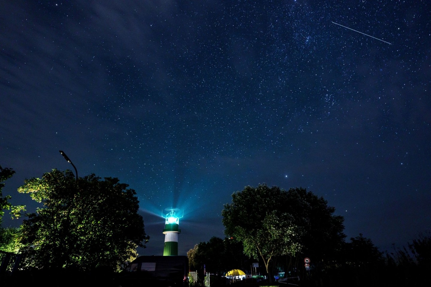 Eine Sternschnuppe zieht über dem Leuchtturm Bülk am Ufer der Ostsee ihre Bahn.