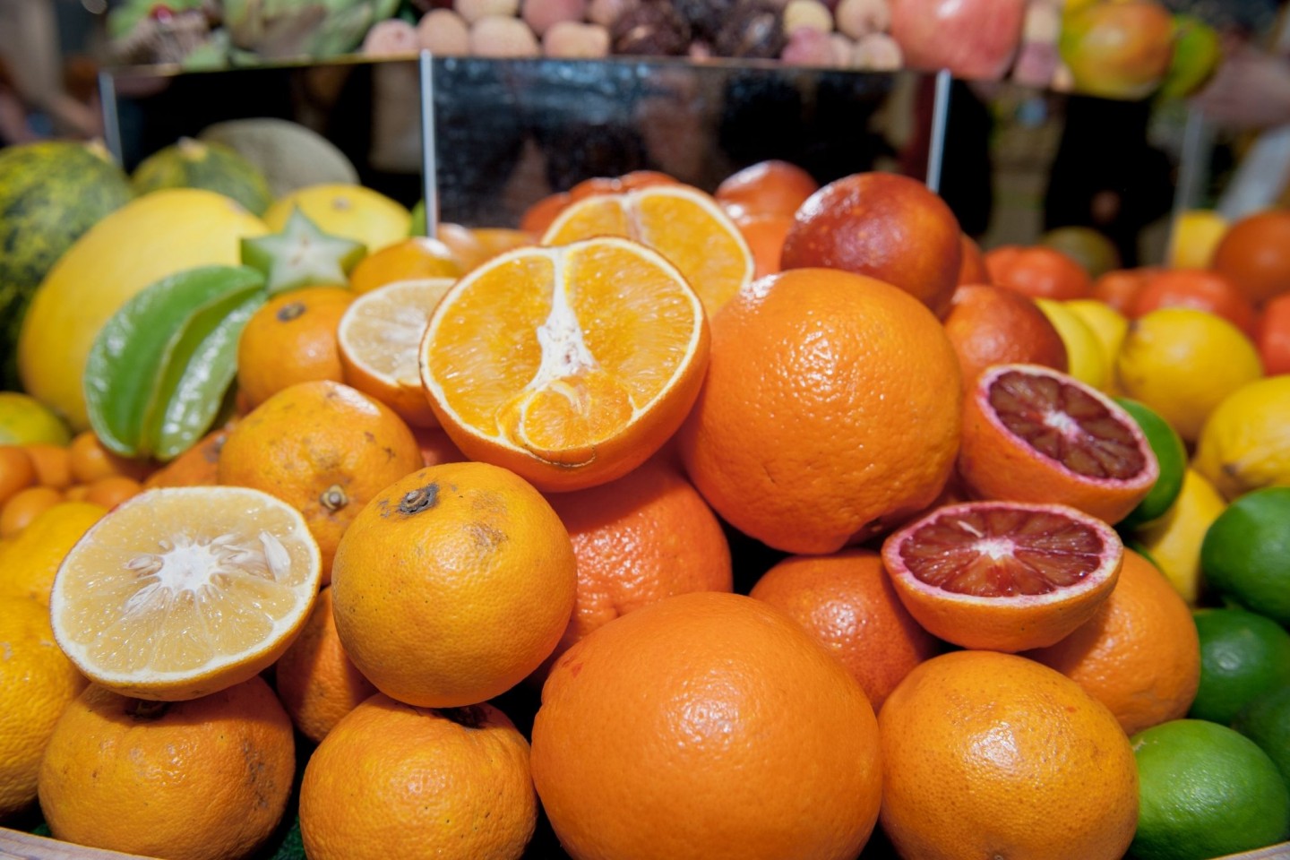 Orangen liegen mit anderen Zitrusfrüchten in Körben auf der Messe 