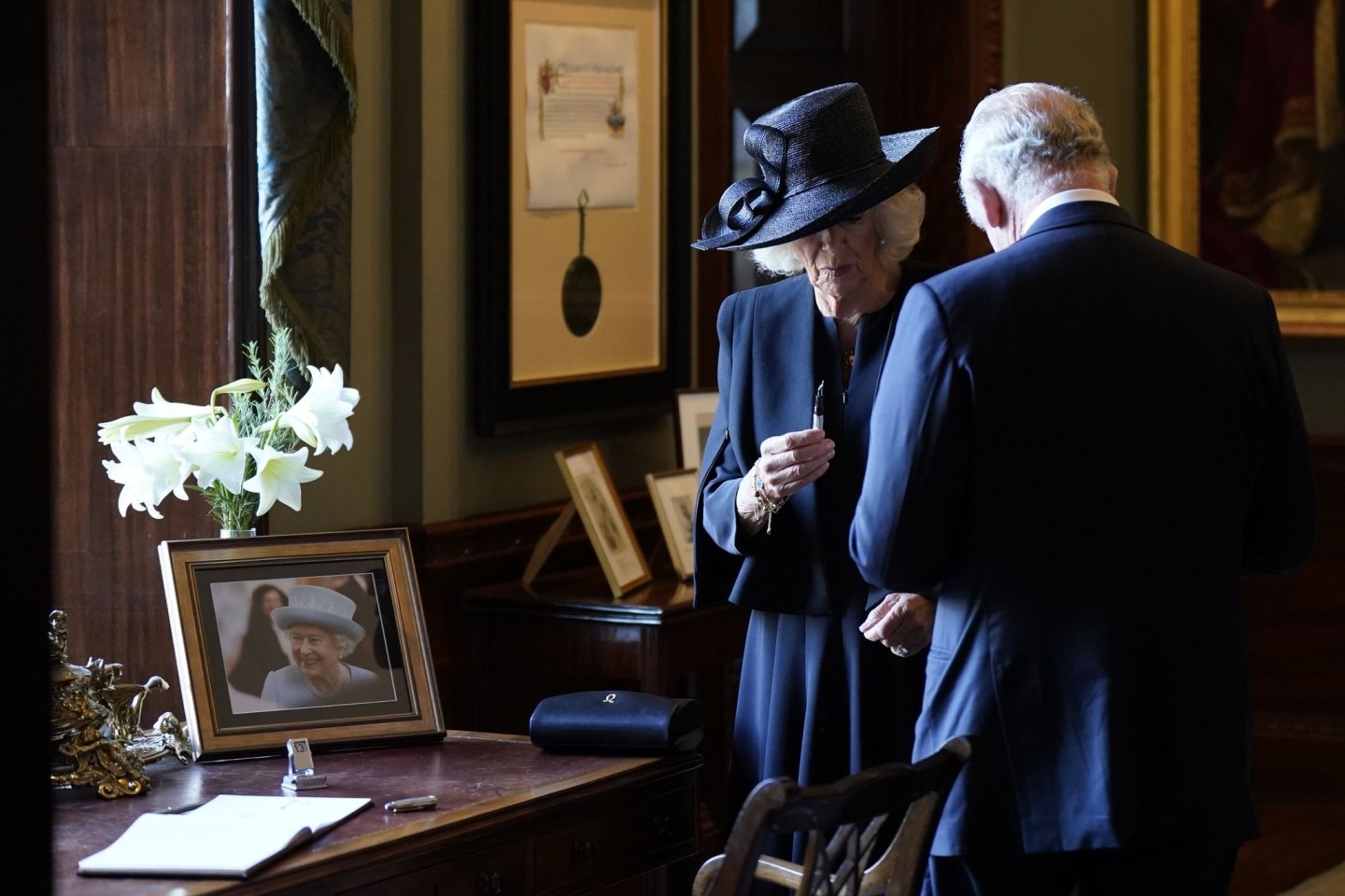Königin Camilla hält einen Füllfederhalter, während sich König Charles III. Tinte von der Hand wischt. Der Monarch wollte sich in Hillsborough Castle in ein Gästebuch eintragen, als de...