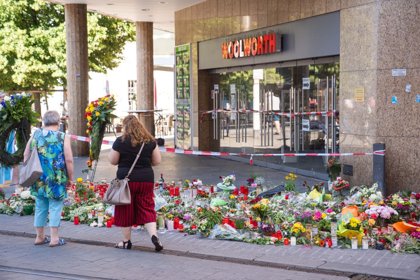 Trauerkerzen und Blumen liegen vor dem Kaufhaus, in dem der Täter Menschen mit einem Messer attackiert hatte.