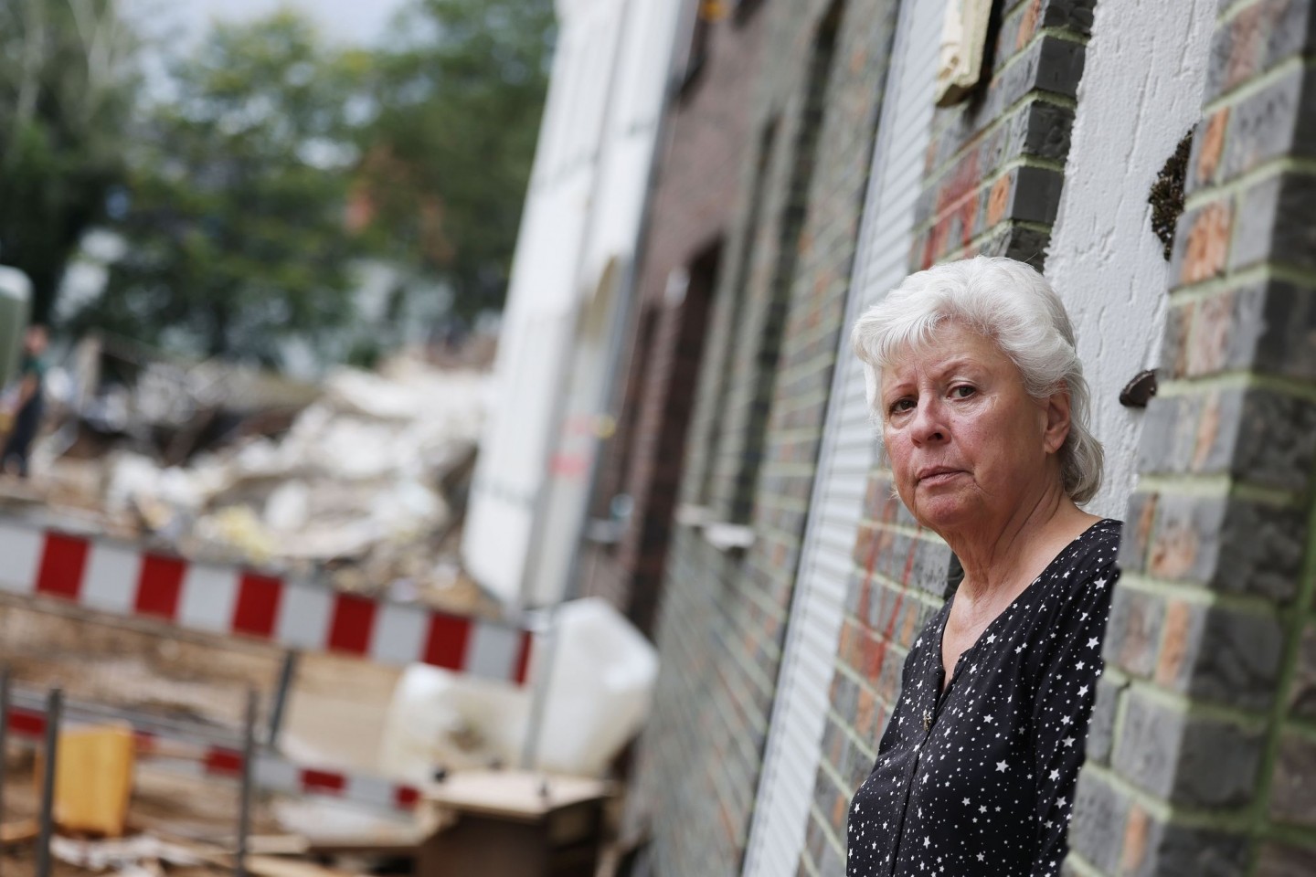 Maria Dunkel, Anwohnerin in Erftstadt-Blessem, blickt aus dem Eingang ihrer Wohnung. In Erftstadt tat sich in der Nacht zum 15. Juli die Erde auf und verschlang mehrere Häuser.