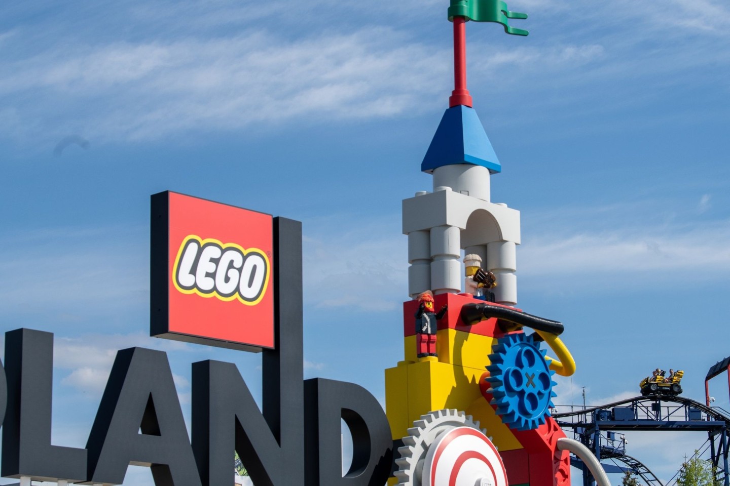 Neben dem Logo am Eingang zum Legoland ist die Achterbahn (r) des Freizeitparks zu sehen (Archivbild).