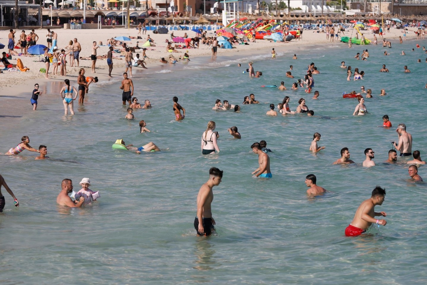 Menschen baden bei großer Hitze bei Magaluf im Mittelmeer.