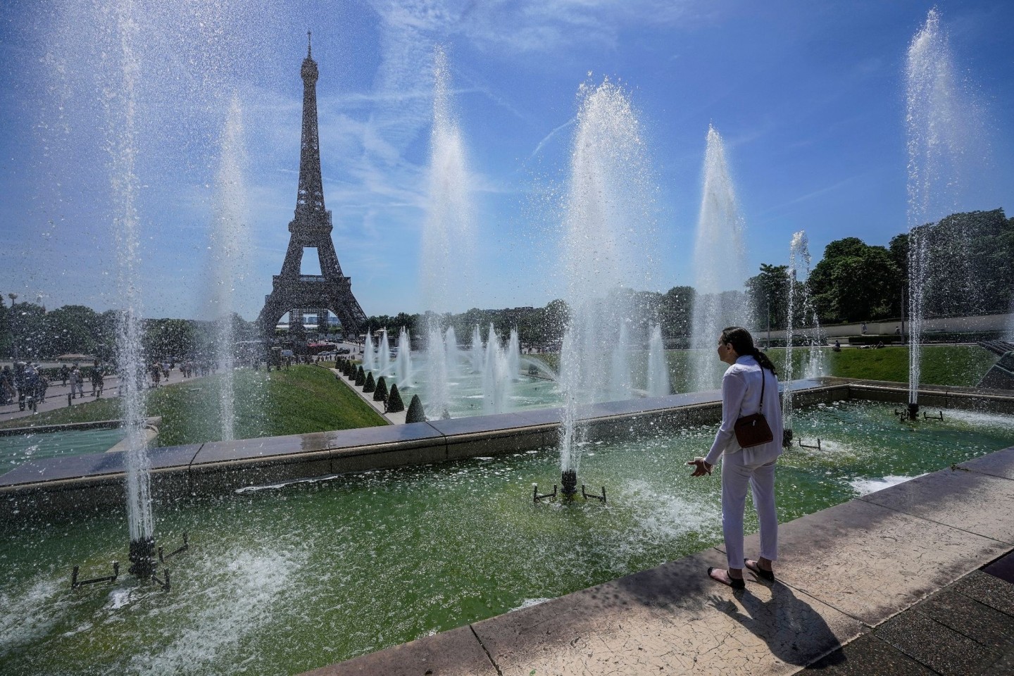 Eine Frau kühlt sich an einem Brunnen in der Nähe des Eiffelturms ab. Wichtige Faktoren für die Zunahme von Hitzewellen insbesondere in Westeuropa sind aus Sicht von Potsdamer Forschern V...