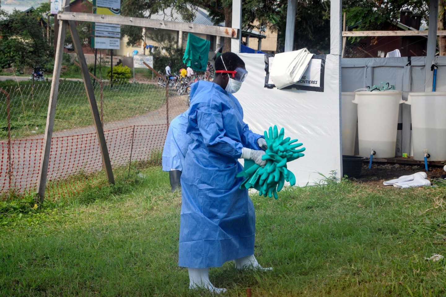 Ein Mitarbeiter in medizinischer Schutzkleidung trägt Schutzhandschuhe in einem Krankenhaus, in dem ein Ebola-Opfer isoliert wurde.