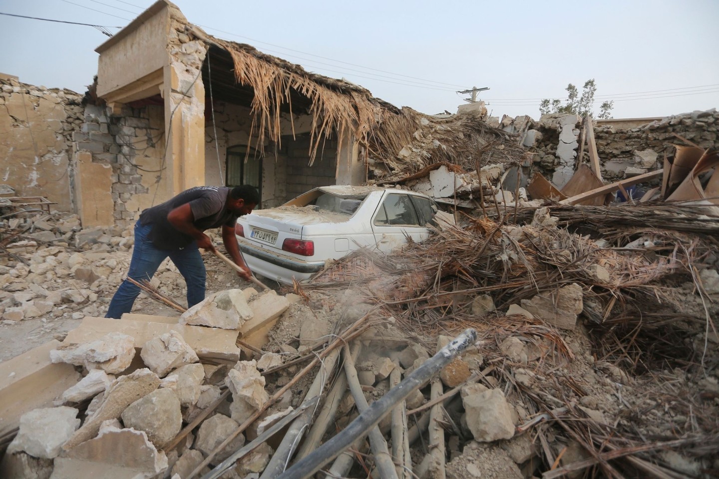 Ein Mann räumt die Trümmer nach einem Erdbeben im Dorf Sayeh Khosh im Südiran auf.