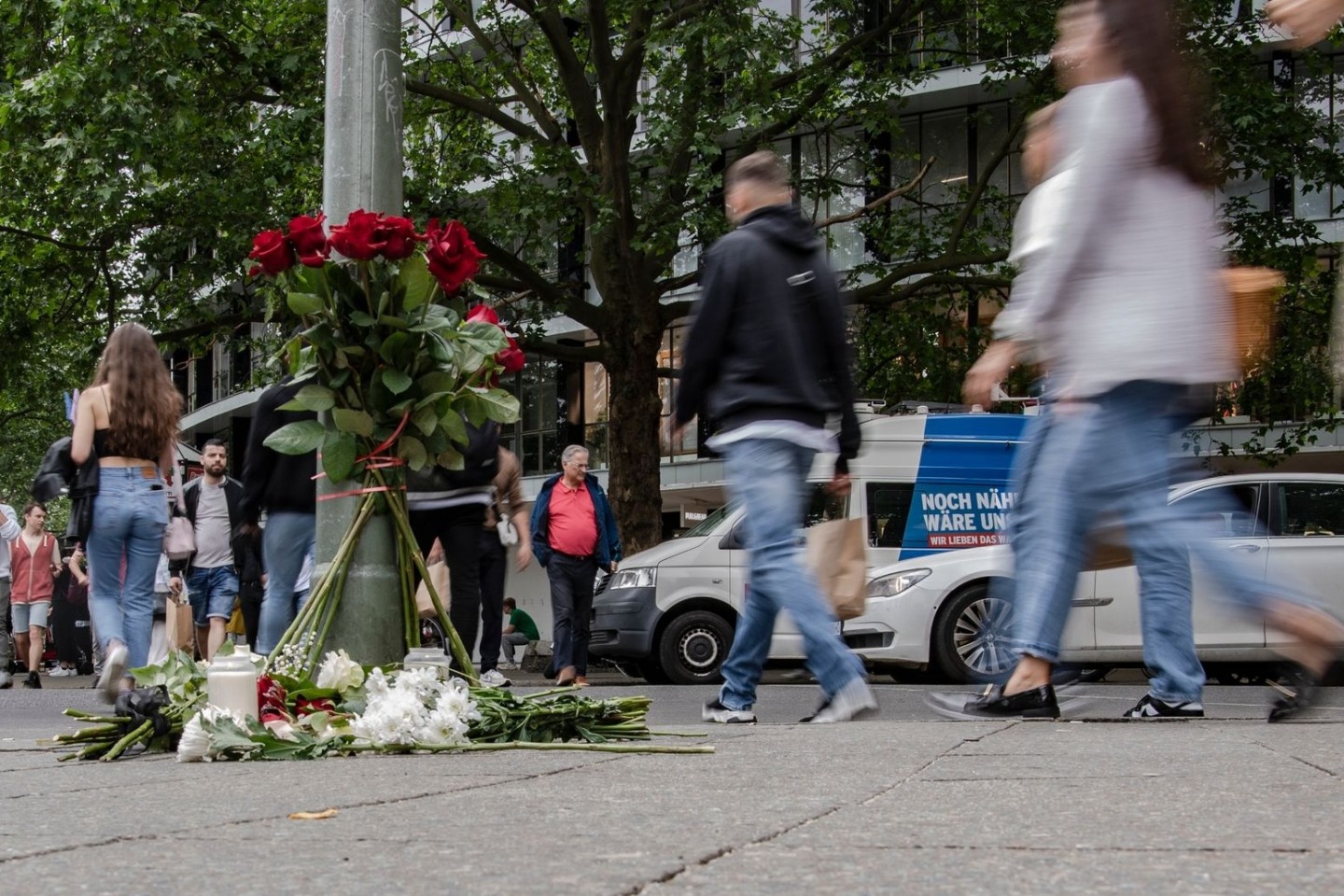 Blumen sind an einem Ampelmast auf der Tauentzienstraße niedergelegt in Gedenken an die getötete Lehrerin und zahlreiche Verletzte.
