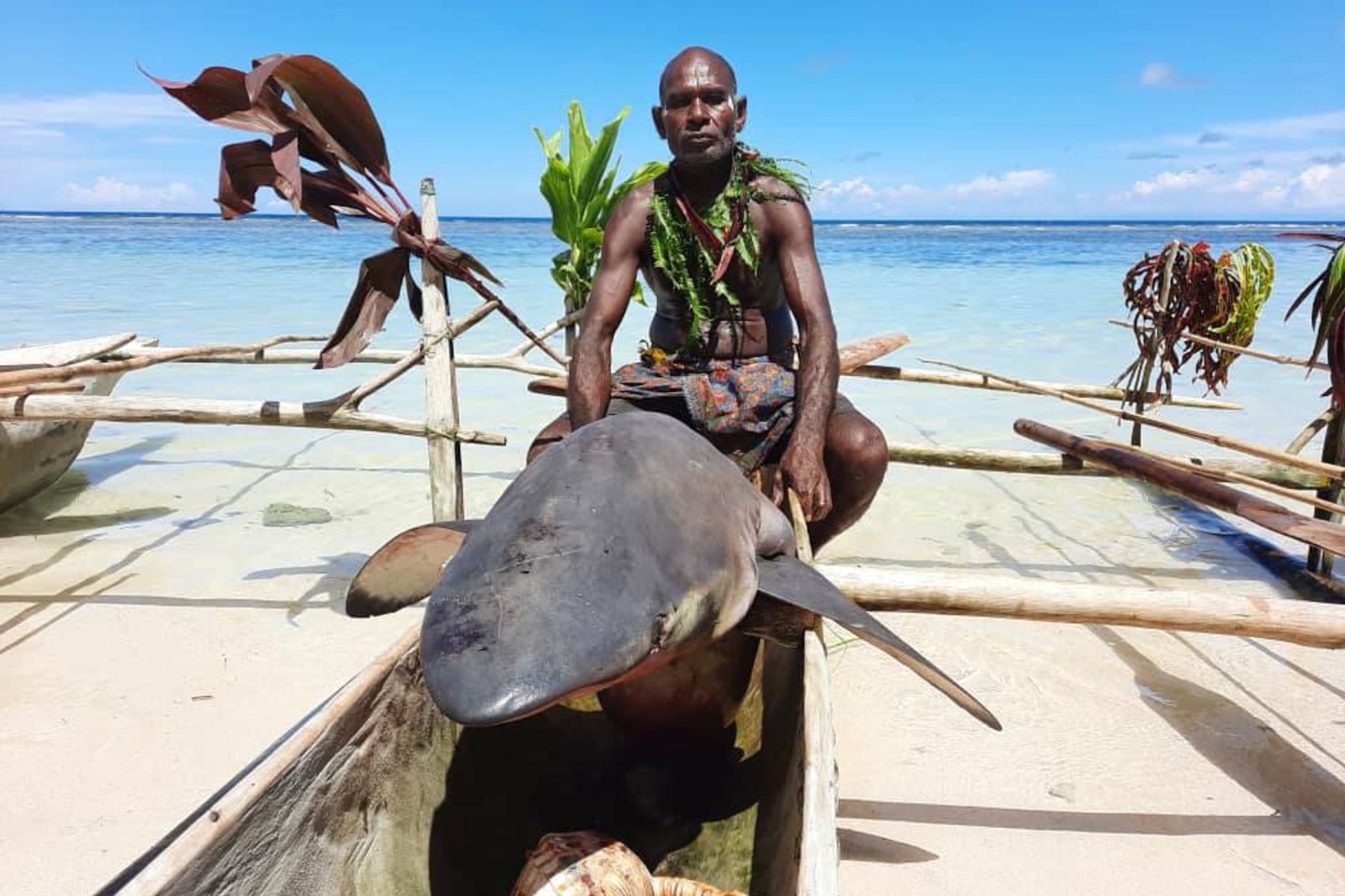 Ein Mann sitzt beim «Shark Calling Festival» auf einem erlegten Hai.