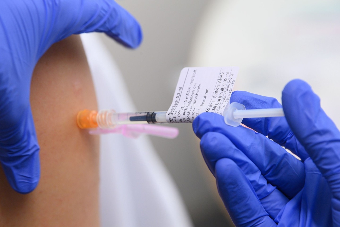 Eine Ärztin impft im Universitätsklinikum in Dresden einen Arztkollegen mit der dritten Impfung gegen das Coronavirus.