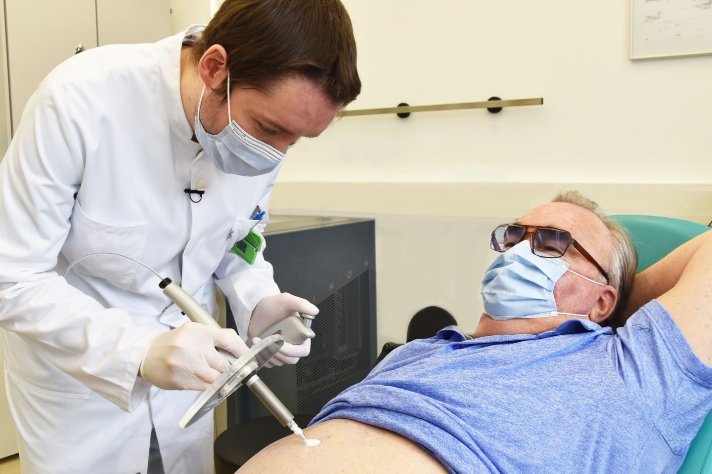 Nuklearmediziner Martin Heuschkel trägt radioaktive Paste beim Patienten Rainer Schnabel auf, die einen Hautkrebs-Tumor abtöten soll.