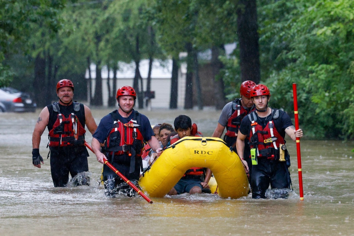 Rettungskräfte der Feuerwehr bringen eine vierköpfige Familie in Dallas mit einem Boot in höher gelegene Gebiete.