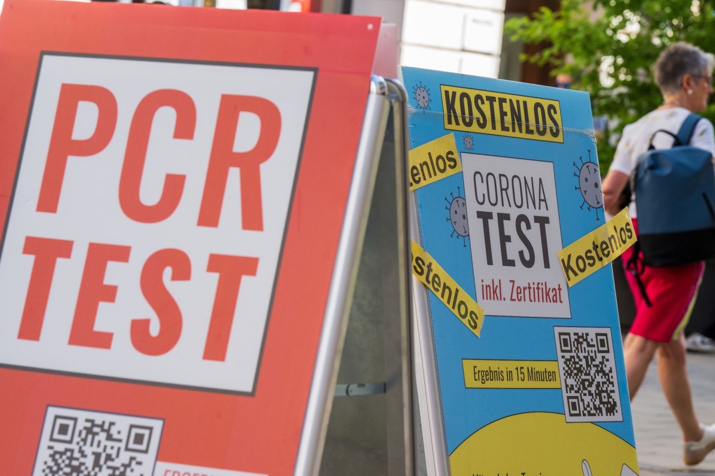 Schilder bewerben vor dem Eingang einer Apotheke in der Münchener Innenstadt Corona-Tests.