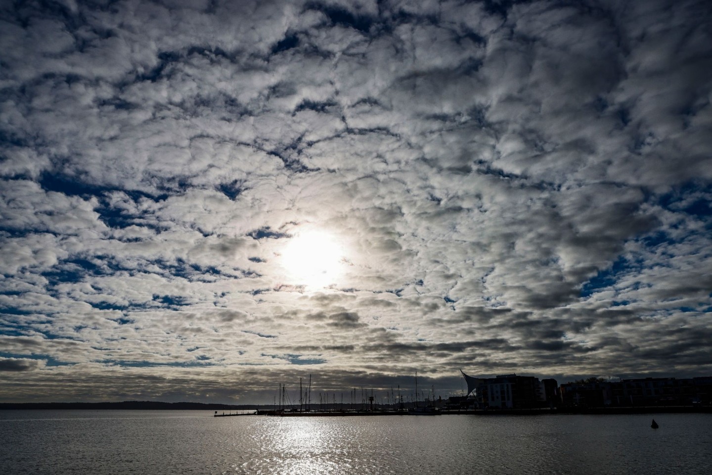 Wolken verdecken die Sonne, die auf den Hafen von Eckernförde (Schleswig-Holstein) scheint.