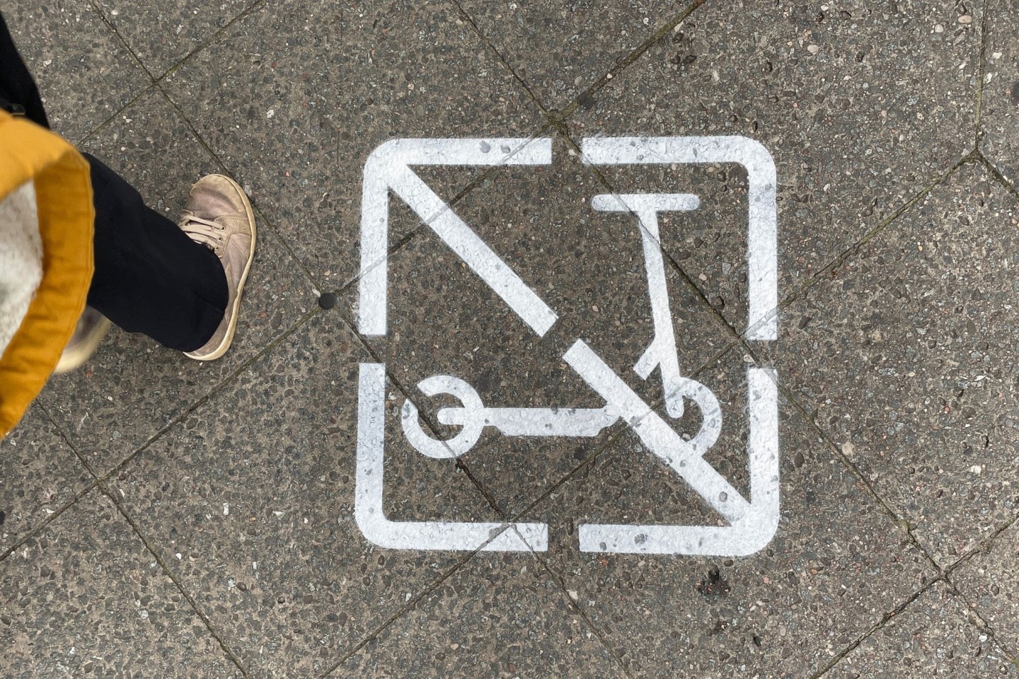 Ein Piktogramm auf einem Gehweg zeigt, dass E-Scooter-Fahrer hier nicht fahren und wild parken dürfen.