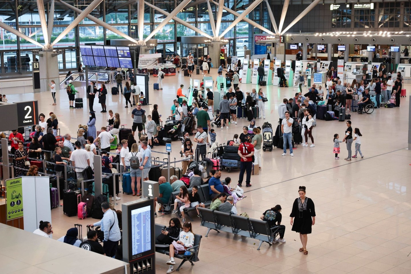 Flugreisende stehen vor den Check-in-Schaltern in Terminal 1 am Airport Hamburg. Mit dem Beginn der Sommerferien in Schleswig-Holstein, Mecklenburg-Vorpommern und Hamburg erwartet der Flugha...