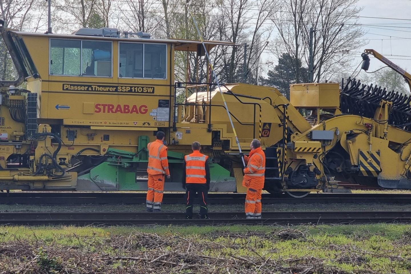 Bahn-Mitarbeiter untersuchen nach dem Unfall die Leitung in Langenhagen.
