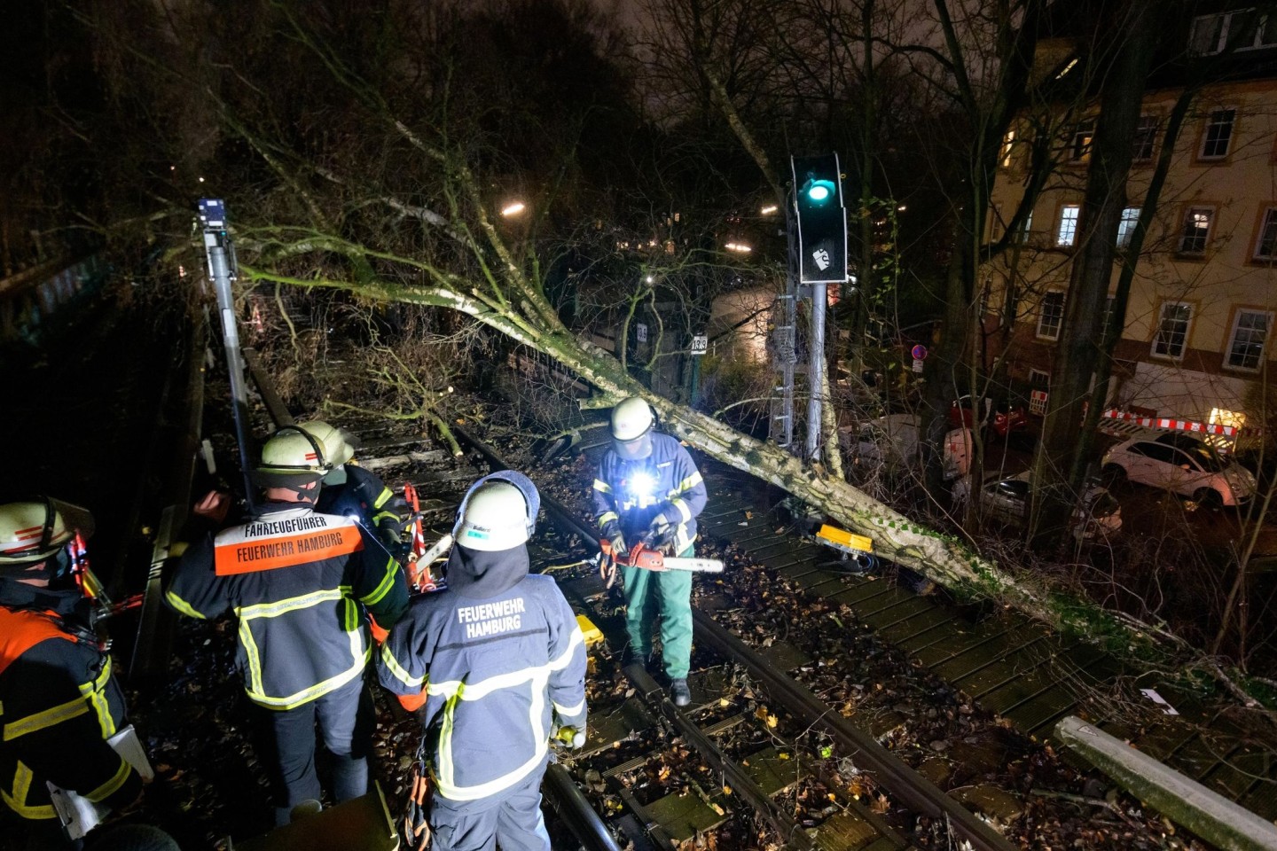 Feuerwehrleute beseitigen einen umgestürzten Baum von den Gleisen der U3.