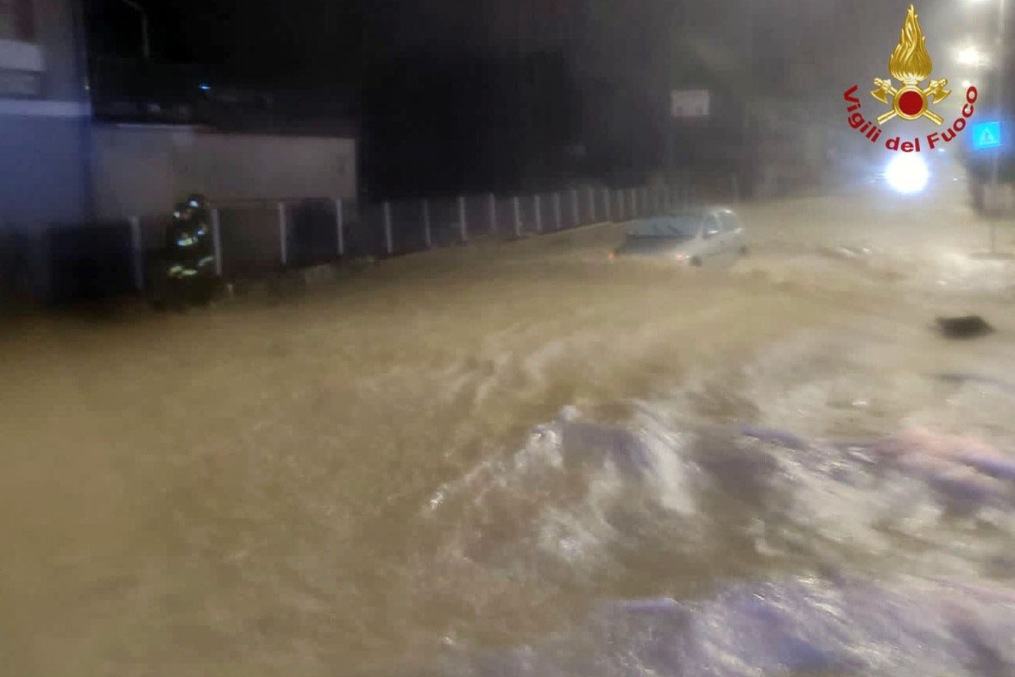 Auf einer überfluteten Straße treibt ein Auto in Kalabrien durch die Wassermassen.