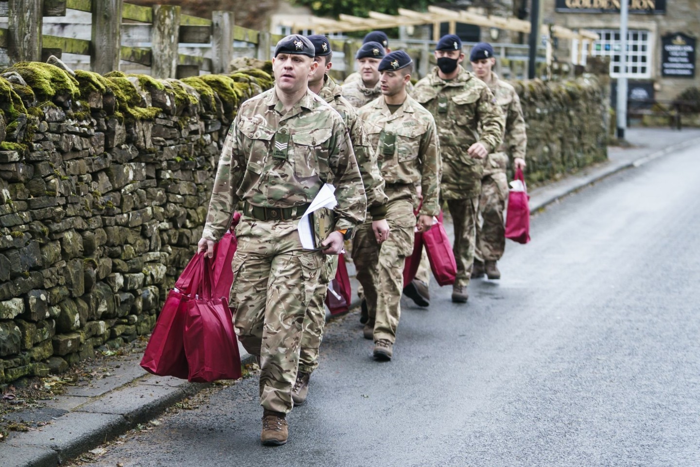 Angehörige der Streitkräfte tragen Versorgungspakete, um sie an Betroffene im britischen St. John's Chapel zu verteilen.
