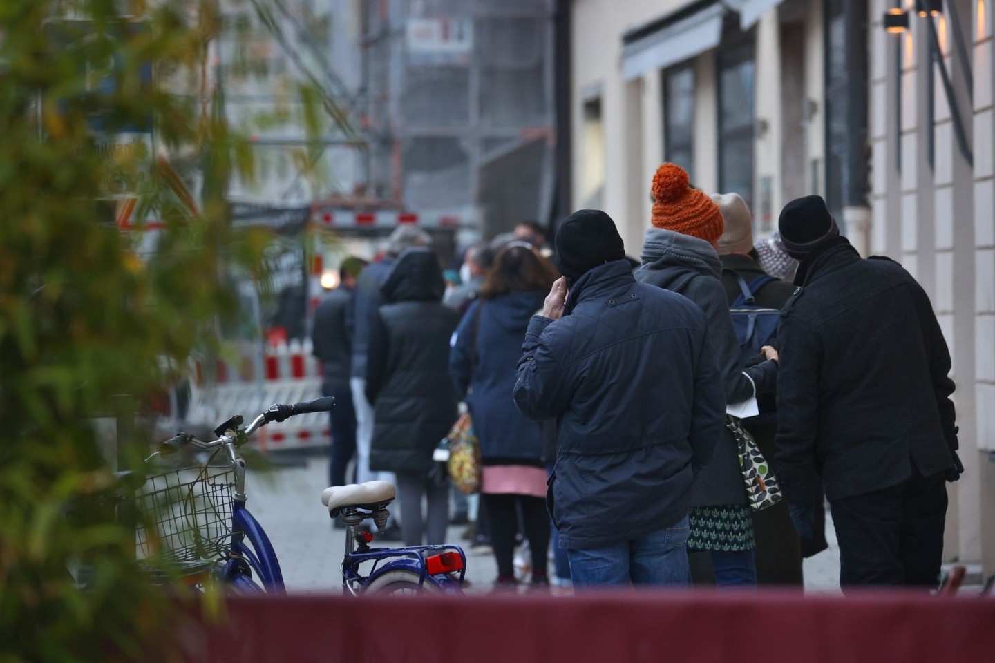 Menschen warten in einer langen Schlange vor einem Corona-Test- und Impfzentrum in Augsburg.