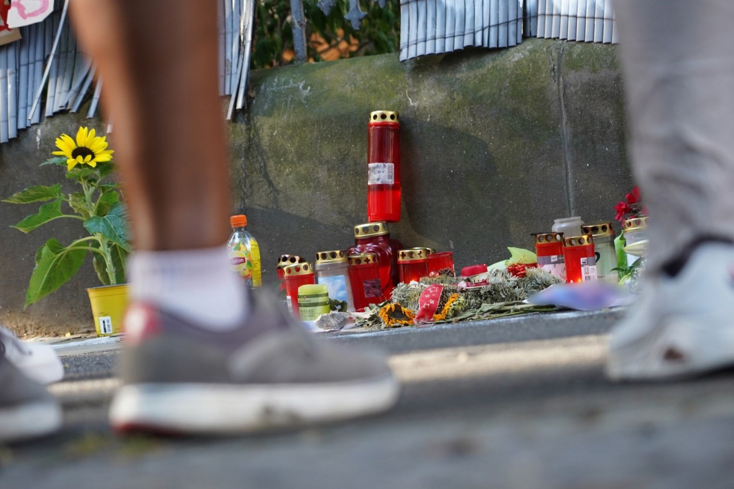 Menschen gedenken mit Kerzen und Blumen eines von der Polizei erschossenen Jugendlichen.