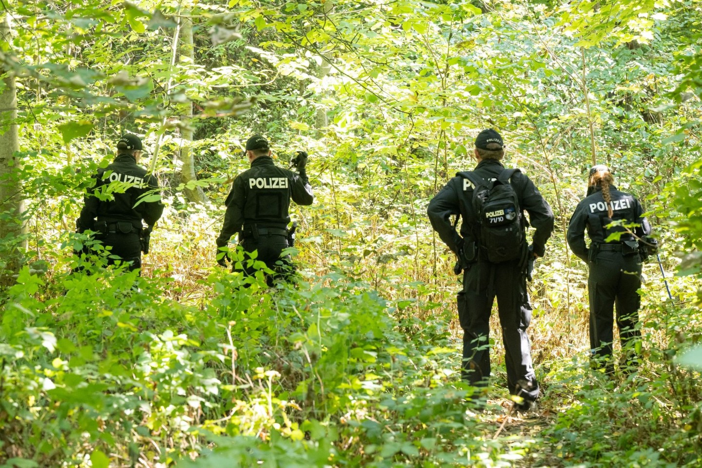 Polizisten durchsuchen im August 2022 ein Waldstück nach Spuren und Gegenständen.