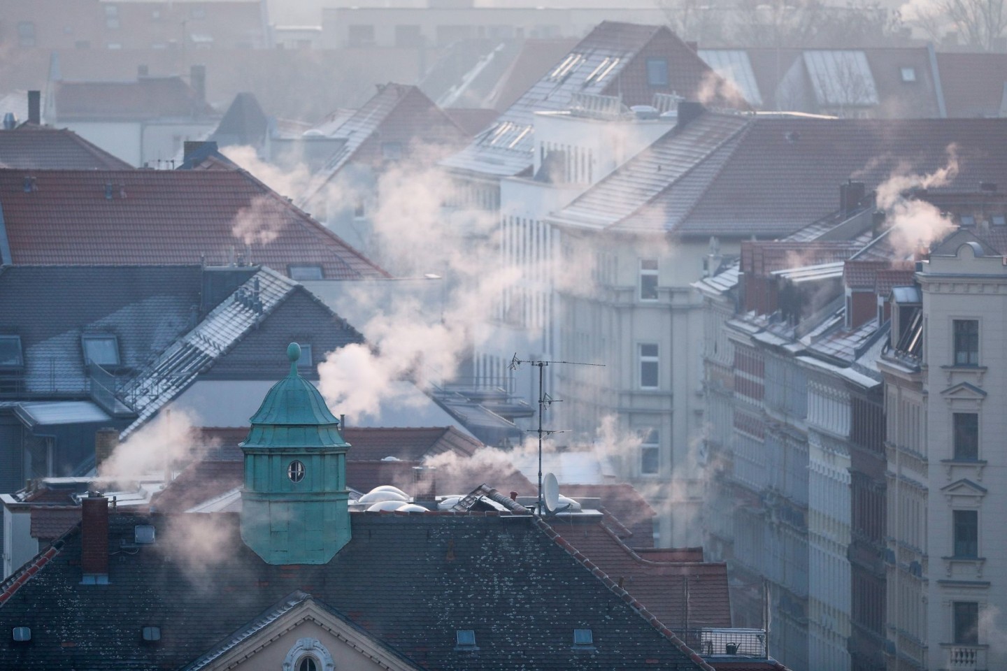 Rauch strömt aus Kaminen auf Dächern von Mehrfamilienhäuser.