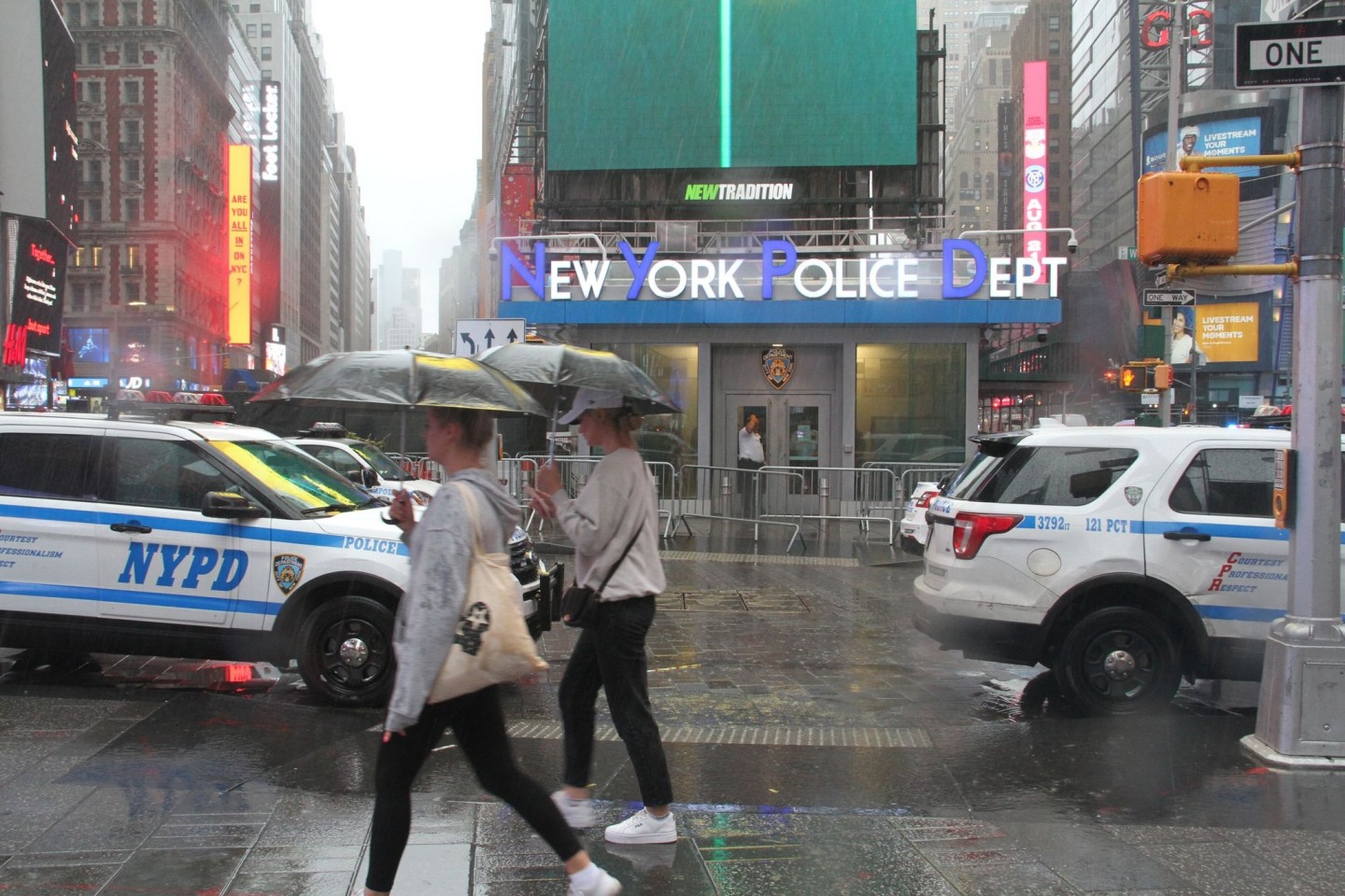 Fußgängerinnen mit Regenschirmen am Times Square in New York.