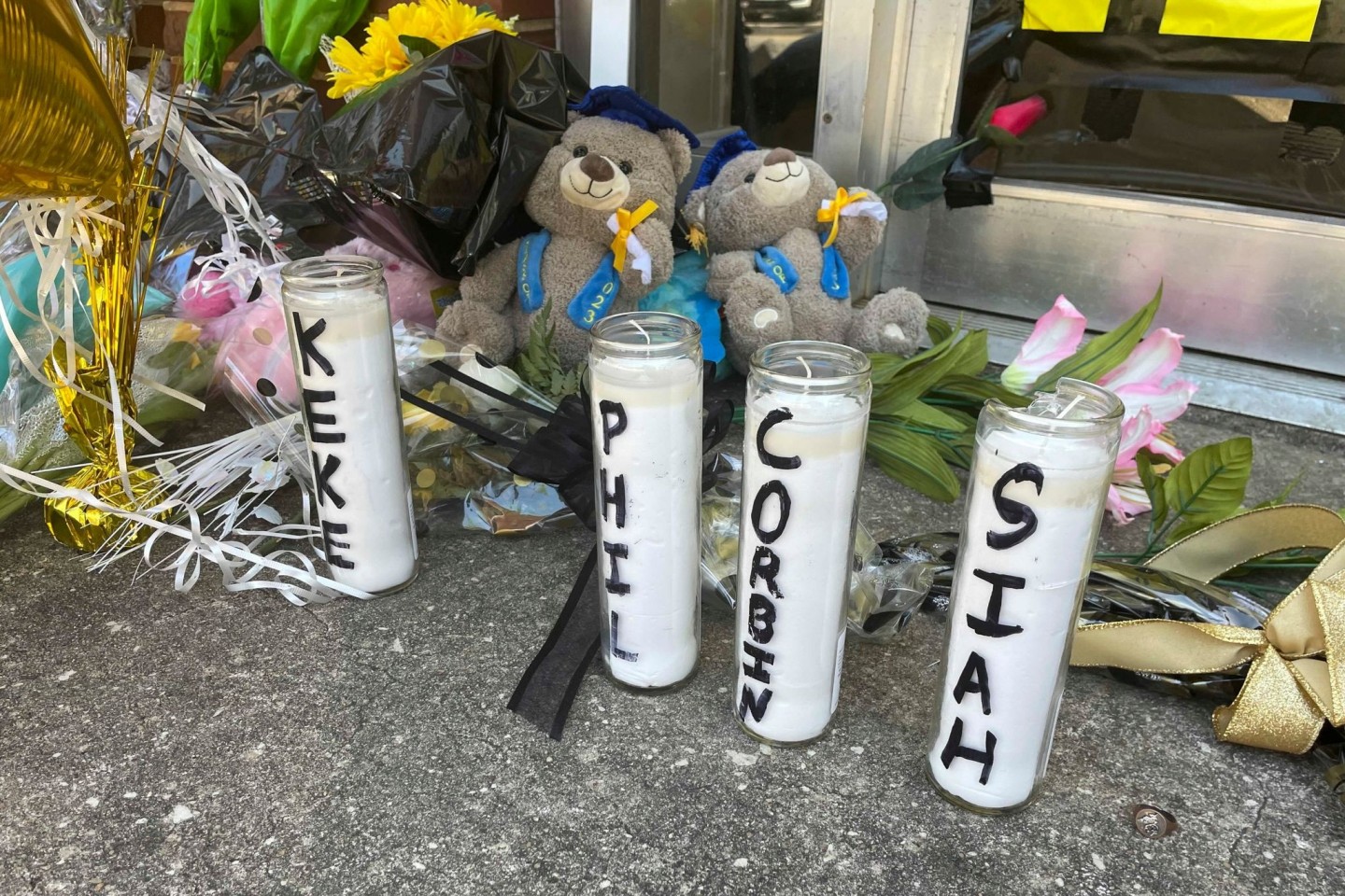 Kerzen mit den Namen der vier bei Schüssen getöteten Jugendlichen und Teddybären mit Abschlussmützen vor dem Tanzstudio Mahogany Masterpiece in Dadeville, Alabama.