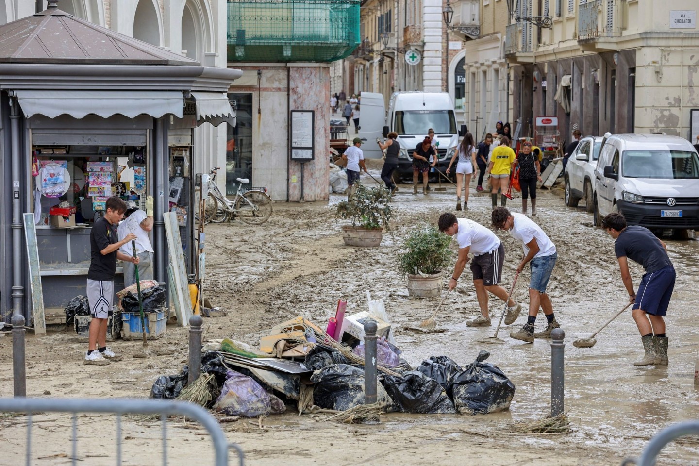 Junge Leute entfernen Schlamm von einer Straße in Senigallia. Durch heftige Regenfälle ausgelöste Sturzfluten haben Städte im hügeligen Mittelitalien überschwemmt.