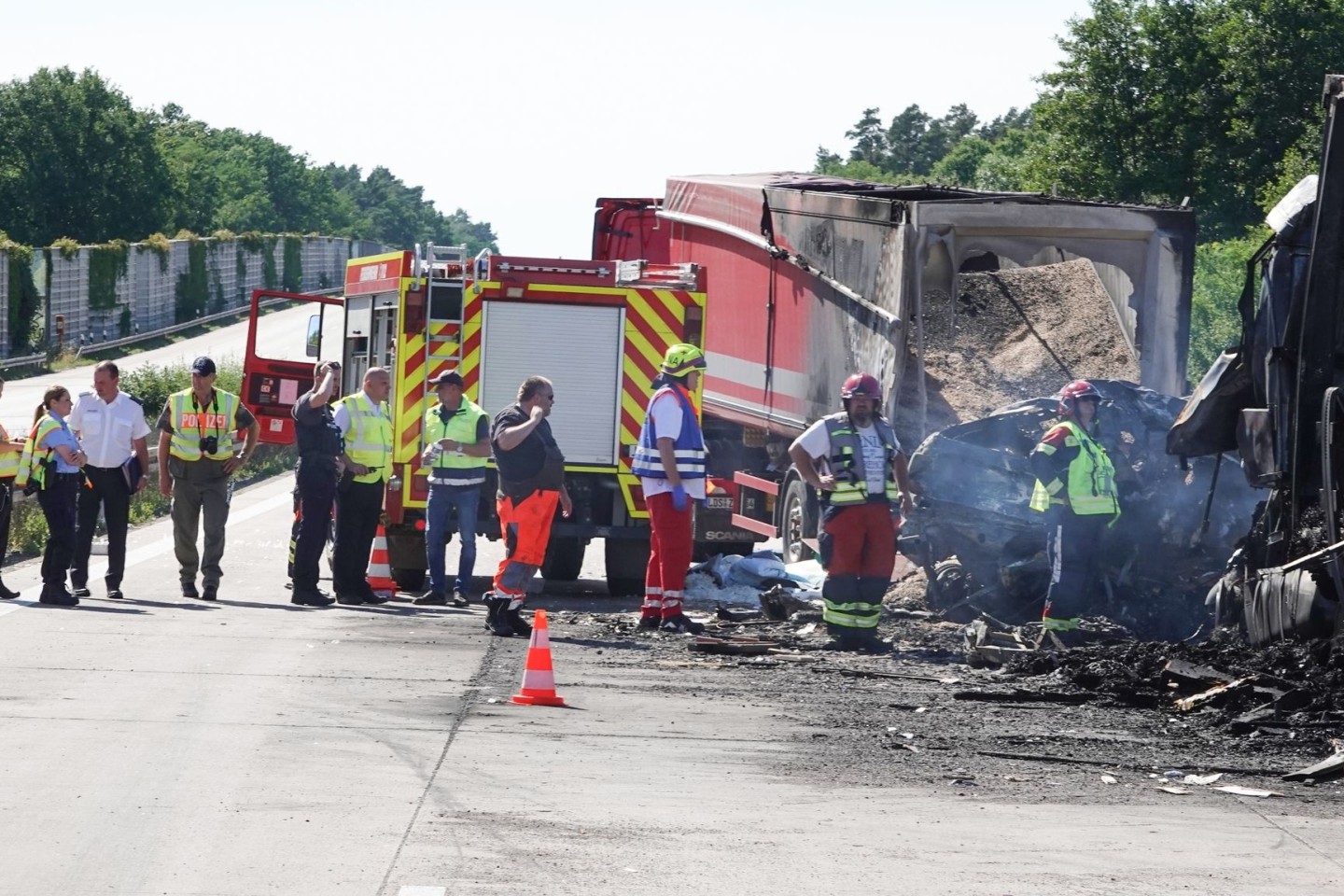 Rettungskräfte stehem nach dem schweren Unfall auf der Autobahn A2 bei Burg in Sachsen-Anhalt.