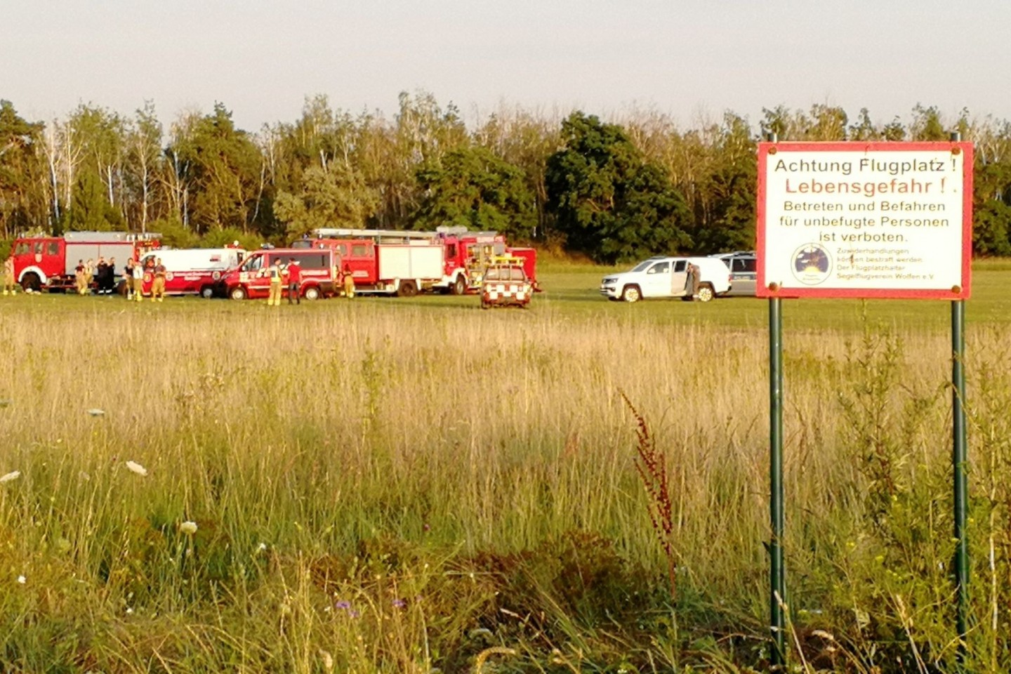 Die Feuerwehr steht am Flugplatz Renneritz an der weiträumig abgesperrten Unfallstelle.