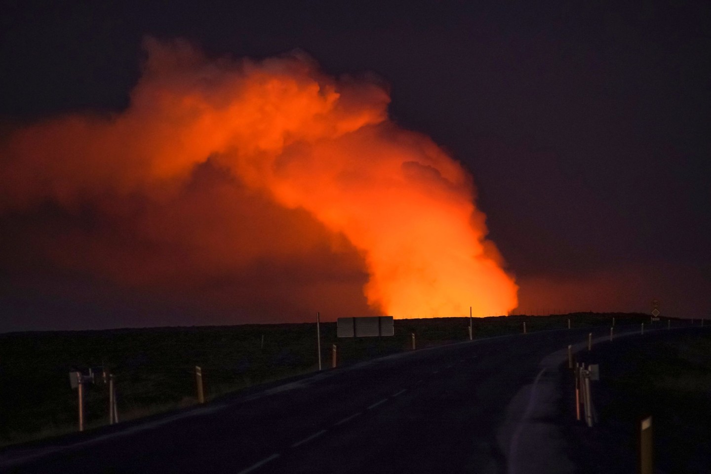 Blick auf die Gaswolke, die von der Lava des ausbrechenden Vulkans beleuchtet wird.
