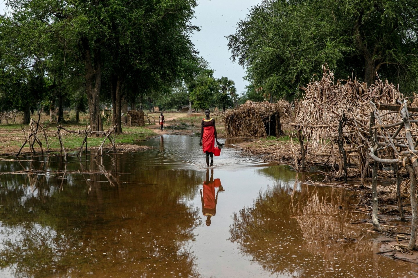 Eine Frau watet durch das Hochwasser zwischen verlassenen Unterkünften im Dorf Majak Awar im Südsudan. Dort sind ganze Bundesstaaten überflutet. Sieben der zehn Klimakrisenherde, die die ...