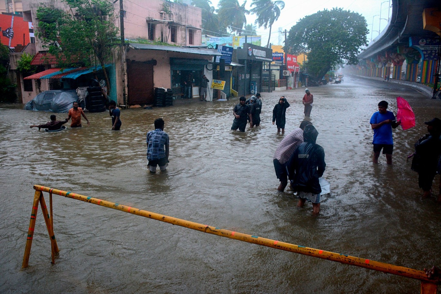 Menschen waten durch eine überschwemmte Straße nach heftigen Regenfällen an der Küste des Golfs von Bengalen.