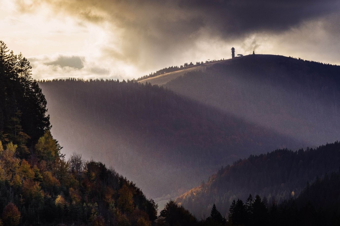 Die Sonnenstrahlen der tiefstehenden Herbstsonne streifen den Feldbergturm auf dem Gipfel des Feldbergs.