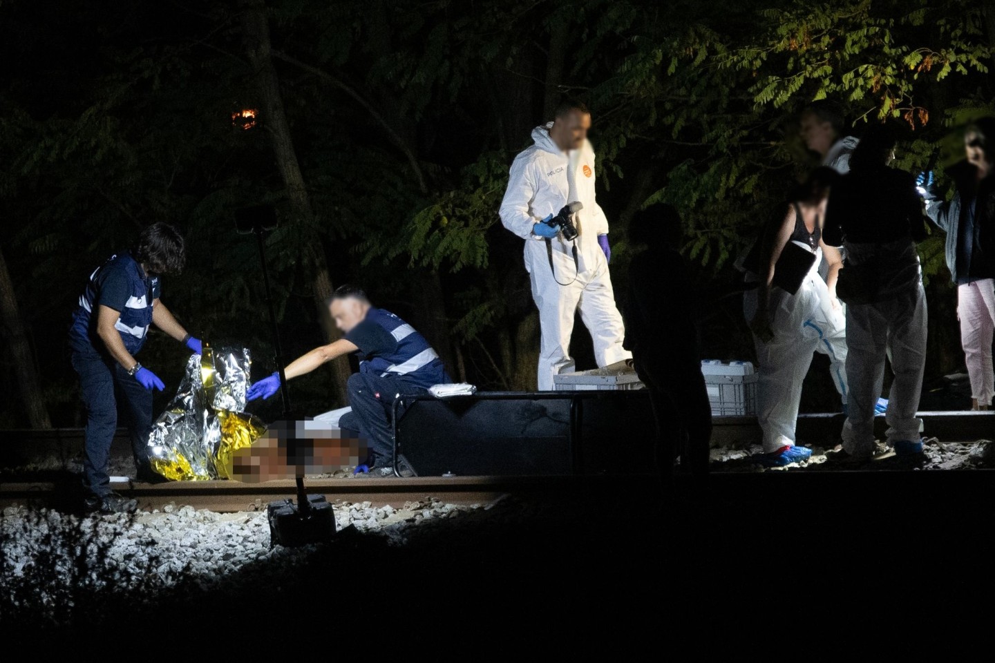 Rettungskräfte arbeiten an der Unglücksstelle, wo eine Gruppe Menschen von einem Zug erfasst wurde.